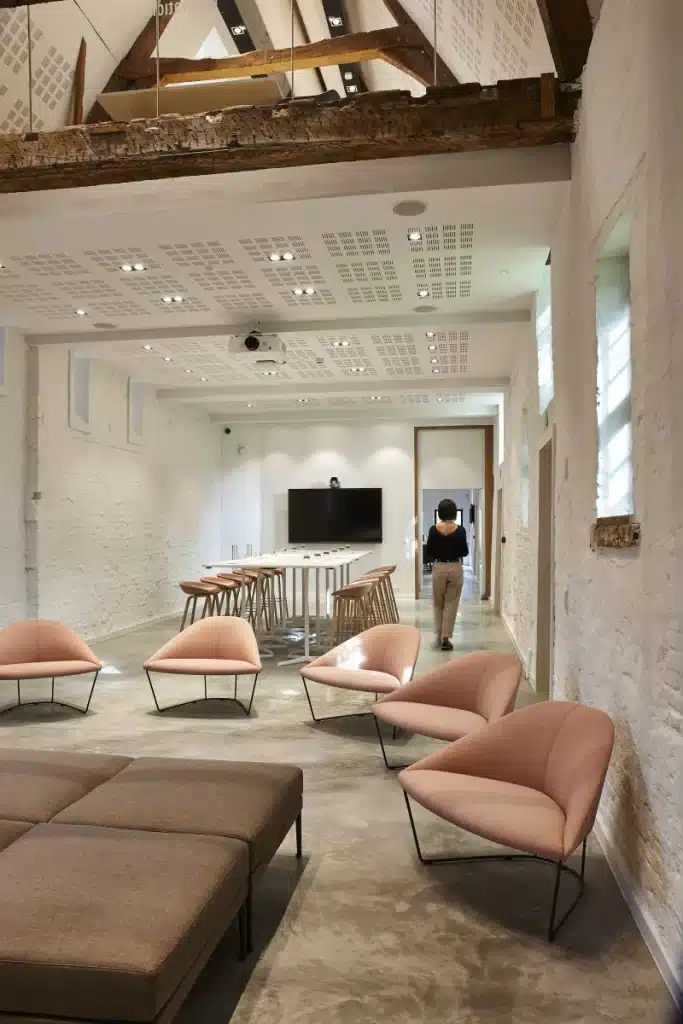 Espace éducatif flexible avec chaises modernes, tables hautes et poutres en bois apparentes