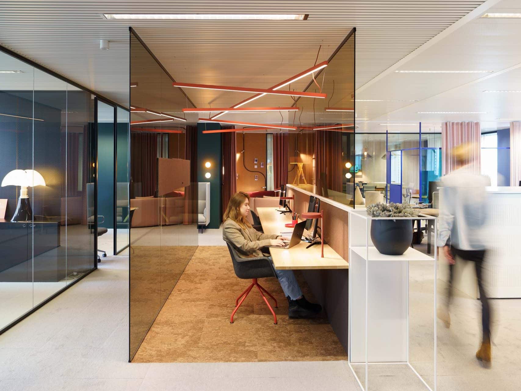 Un employé travaille de manière concentrée dans un espace de travail flexible dans un bureau ouvert avec lumière naturelle
