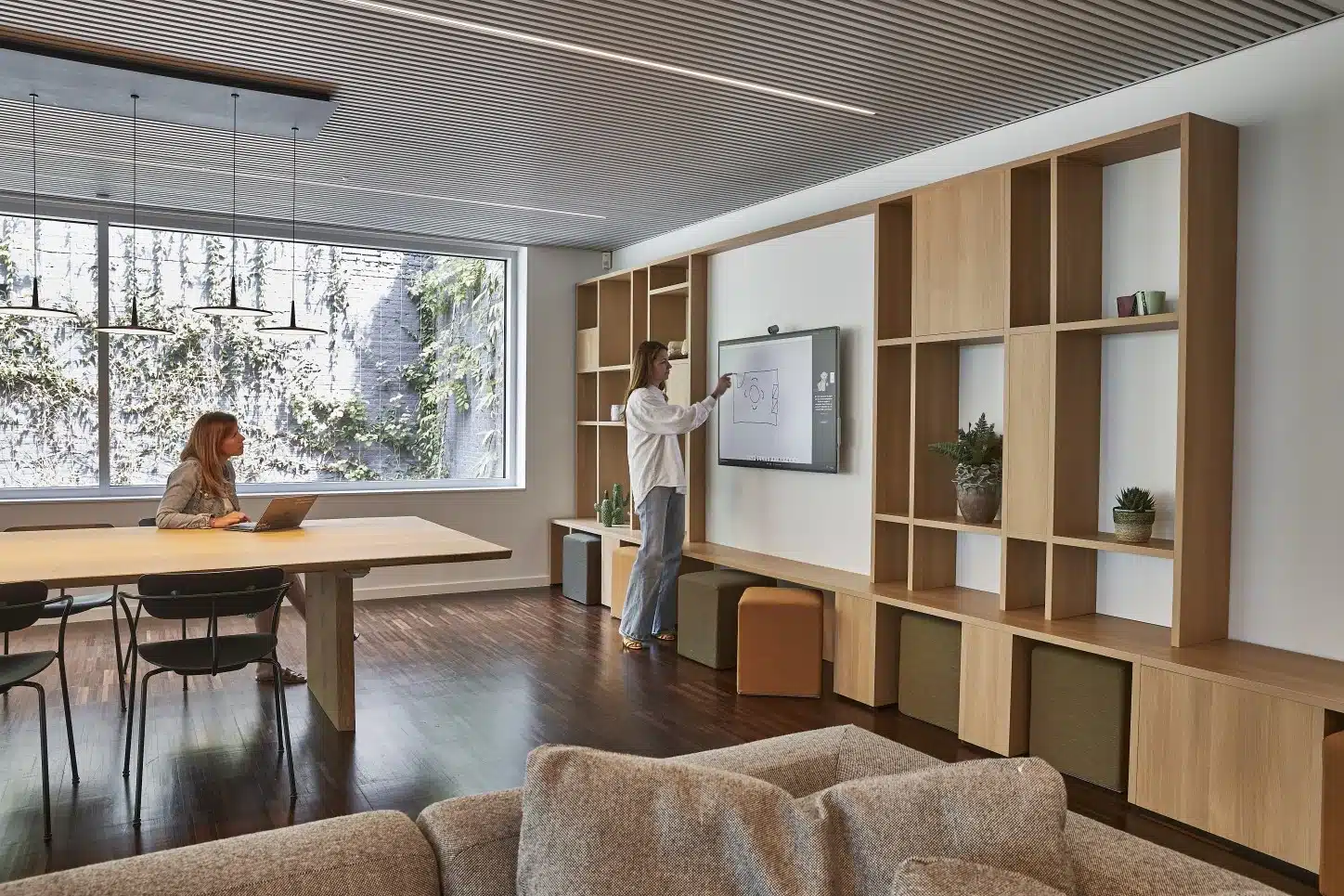 Espace de travail flexible créatif avec écran de présentation et table de réunion