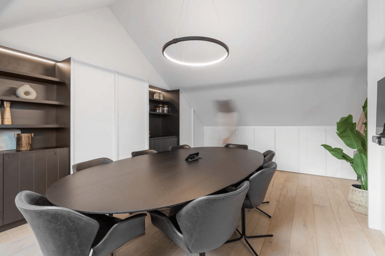 Salle de réunion formelle avec table ovale et éclairage moderne