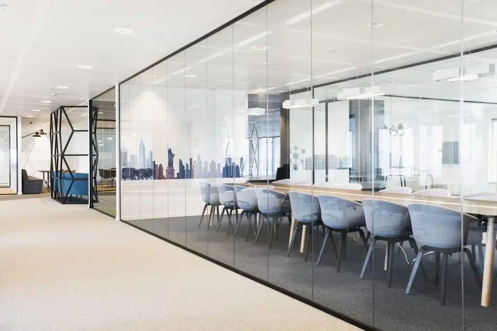 Salle de réunion transparente avec un aménagement moderne et des parois en verre pour une entreprise du secteur industriel
