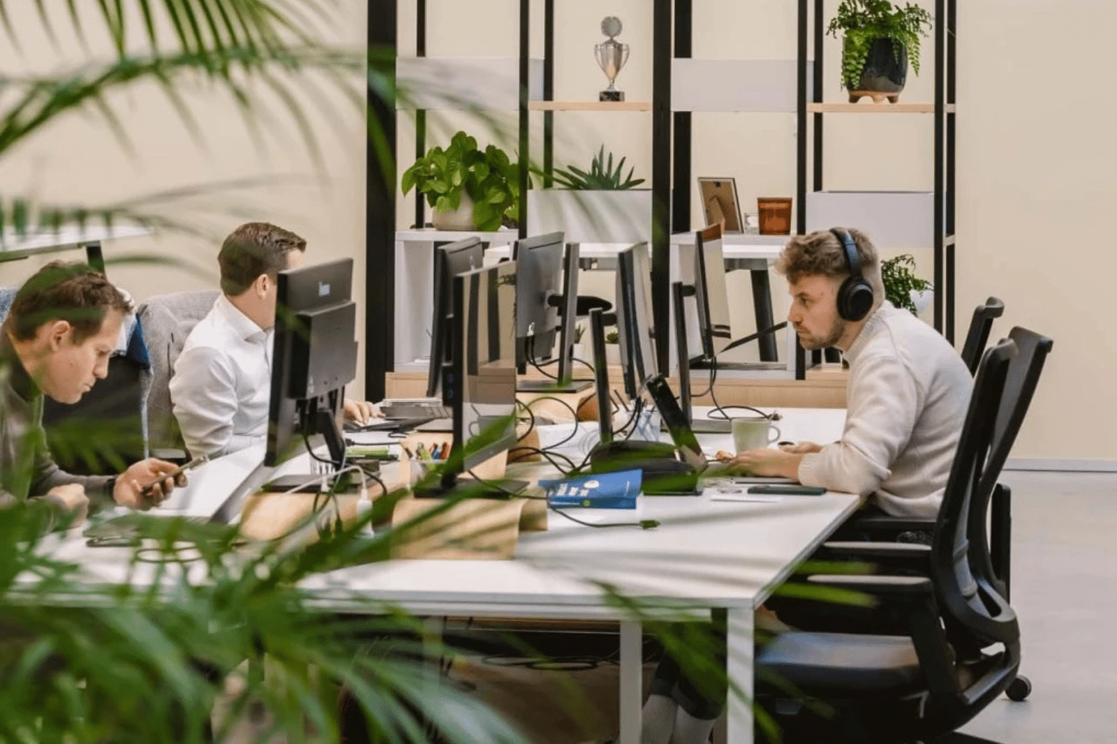 Technische IT-werkplekken met een sfeervolle inrichting en groene accenten
