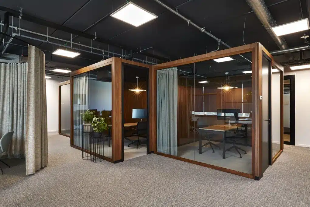 Salle de réunion moderne avec parois vitrées et accents chaleureux en bois pour les professionnels de l'assurance