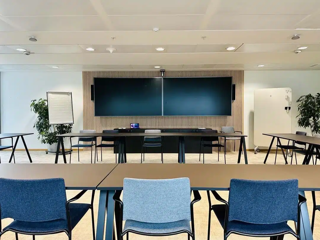 Salle de réunion moderne avec revêtement mural acoustique et mobilier flexible pour un environnement de bureaux industriel