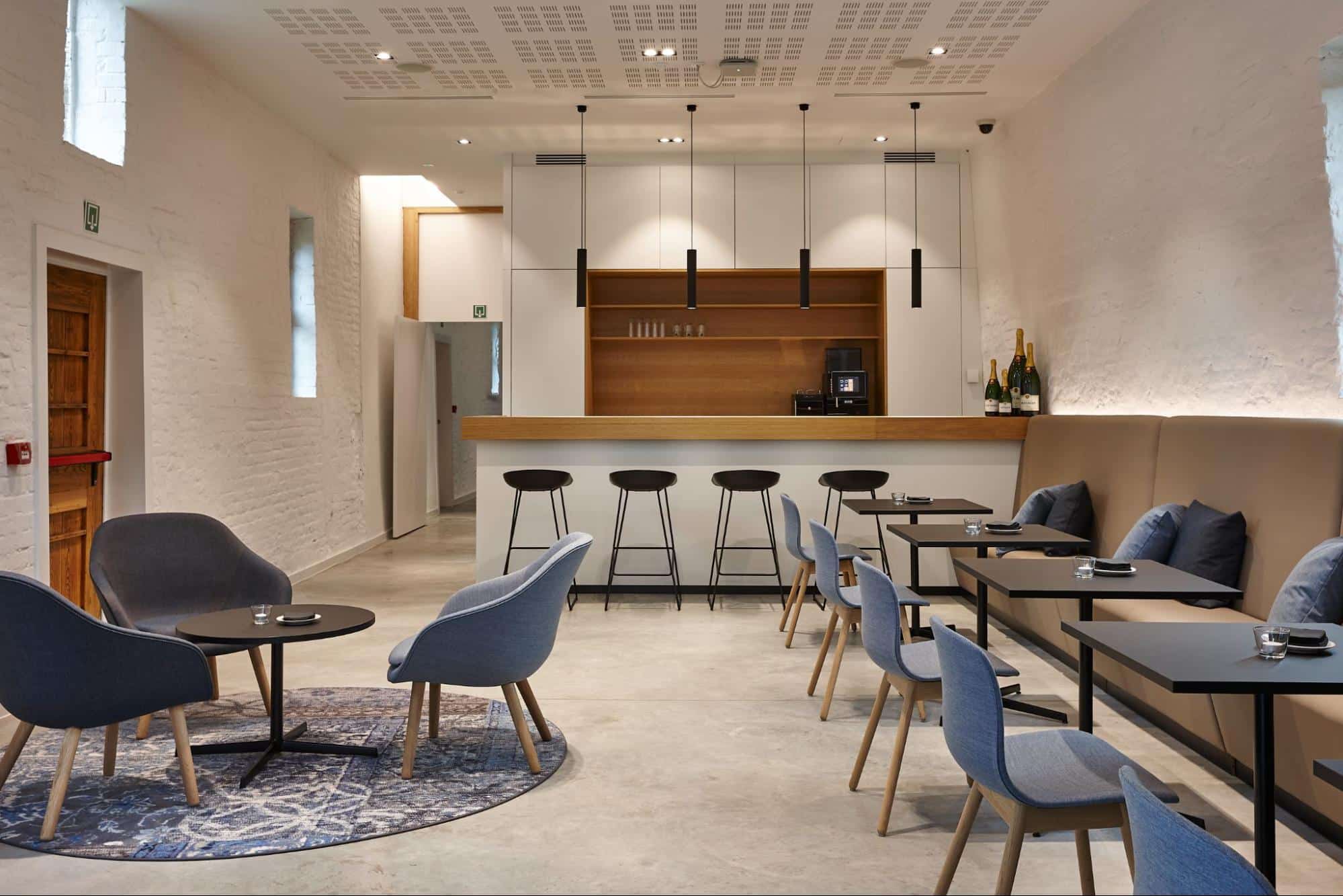 Salle à manger moderne et coin salon avec bar et espace de détente dans un environnement éducatif