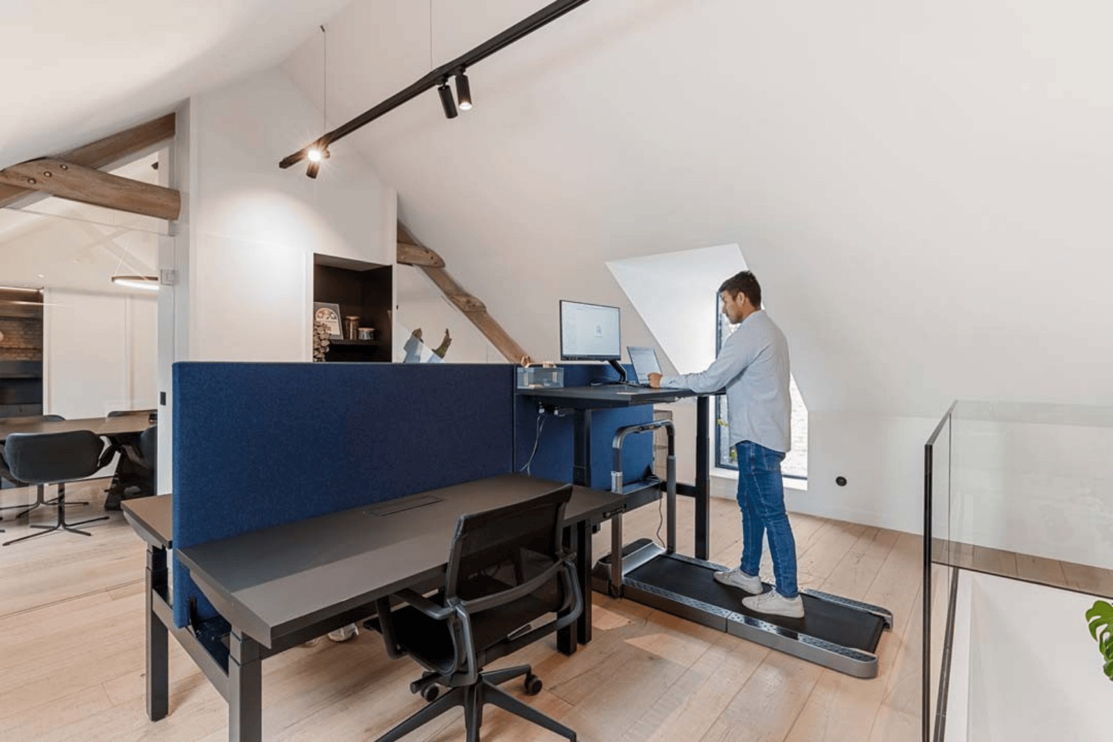 Man werkt aan een laptop op een zit-sta bureau met loopband