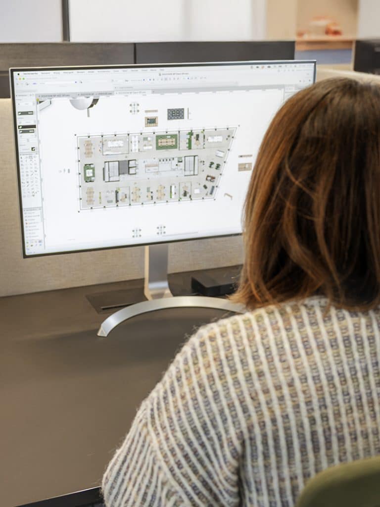 Concepteur travaillant sur l'agencement et la planification spatiale d'une rénovation de bureau sur ordinateur