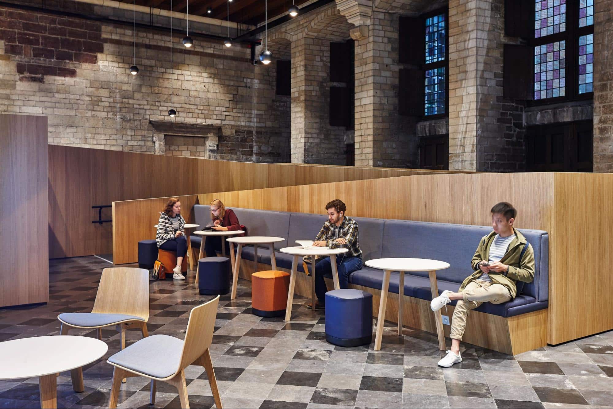 Étudiants travaillant et se détendant dans un espace d'étude moderne avec finitions en bois