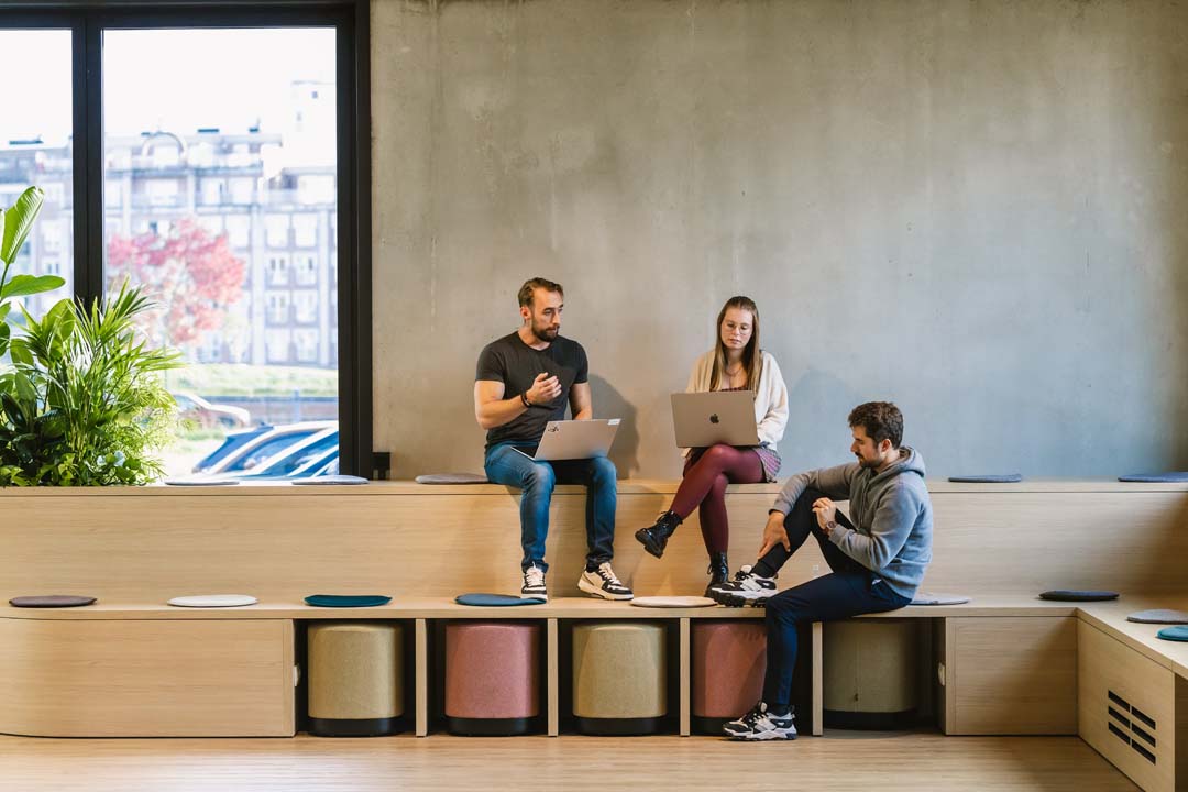 Informele overlegplek met zittribune waar collega’s samen brainstormen in een creatieve kantooromgeving