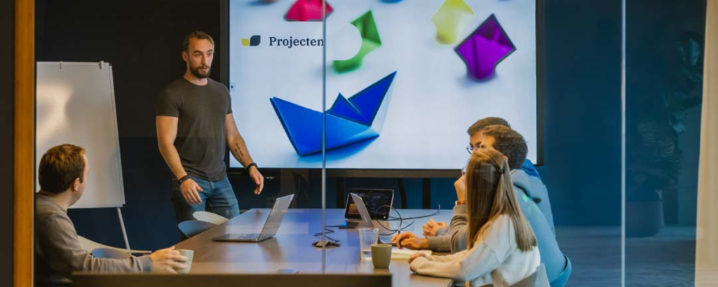Gelukkige collega's volgen een presentatie samen in een moderne vergaderruimte met groot projectiescherm
