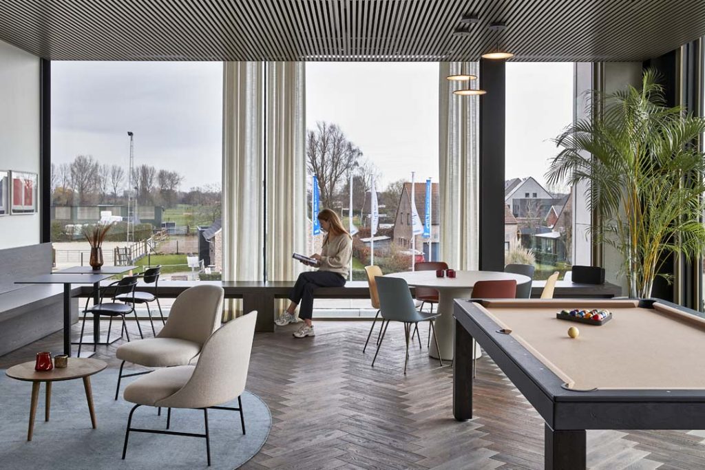 Flexibele kantoorinrichting met informele zithoek en sociale ruimte in het kantoor van de toekomst
