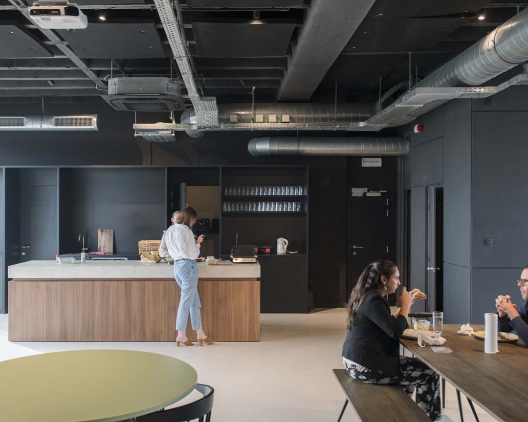 Uitnodigende koffiehoek in het kantoor van de toekomst waar medewerkers elkaar informeel ontmoeten
